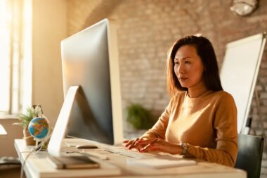Asian businesswoman typing an email on desktop PC in the office